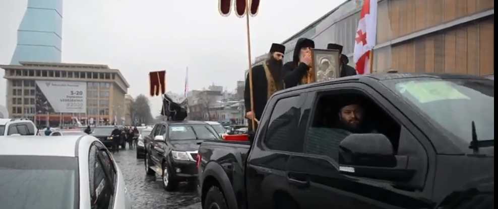 Православные священники окропляют святой водой улицы Тбилиси